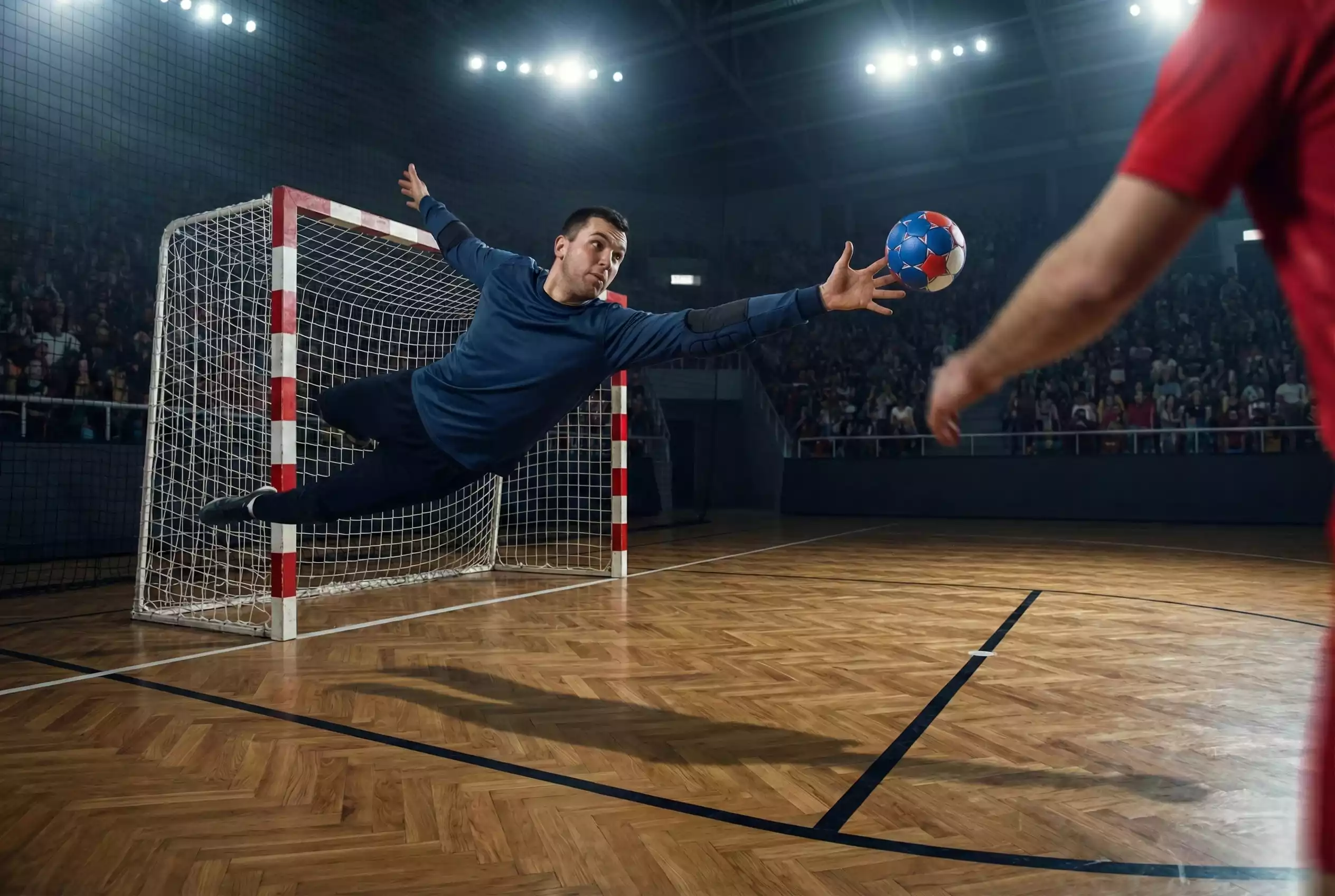 Gardien de handball réalisant un arrêt spectaculaire lors d'un match professionnel